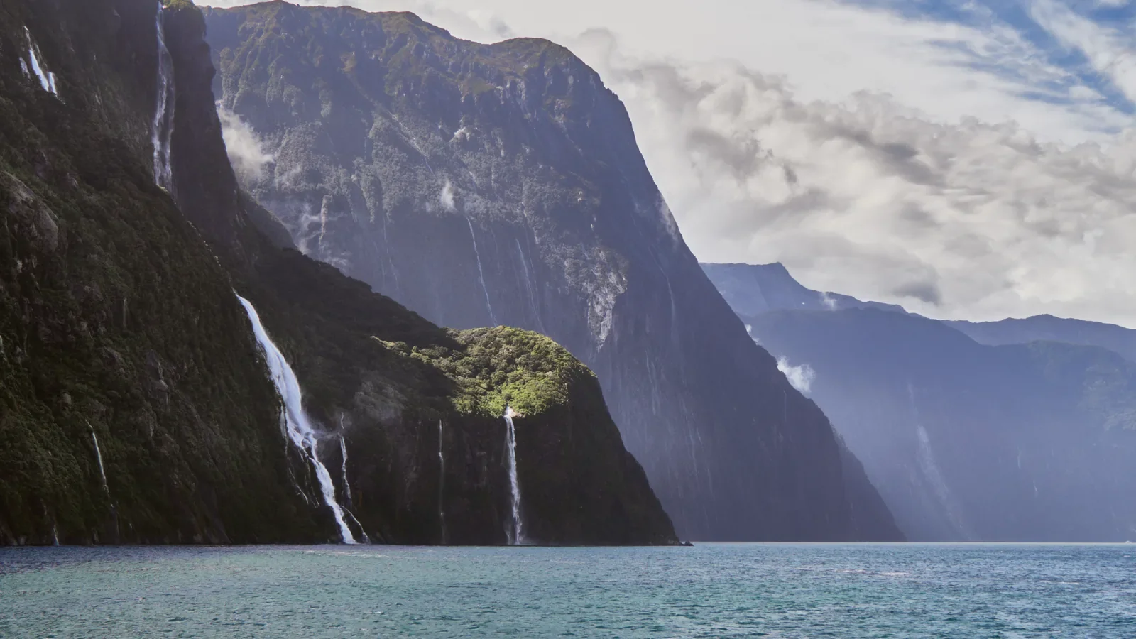 Modern photograph of cliffs, waterfalls and water at Milford Sound / Piopiotahi, showing New Zealand landscape context, not a stamp specimen