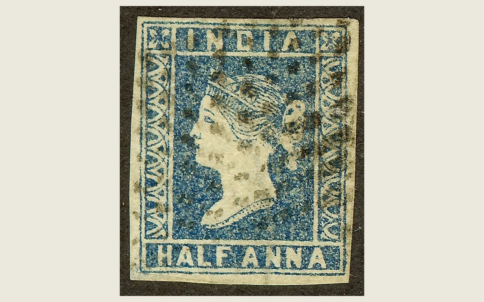 Source scan of a blue India HALF ANNA Queen Victoria postage stamp with all four imperforate paper edges visible