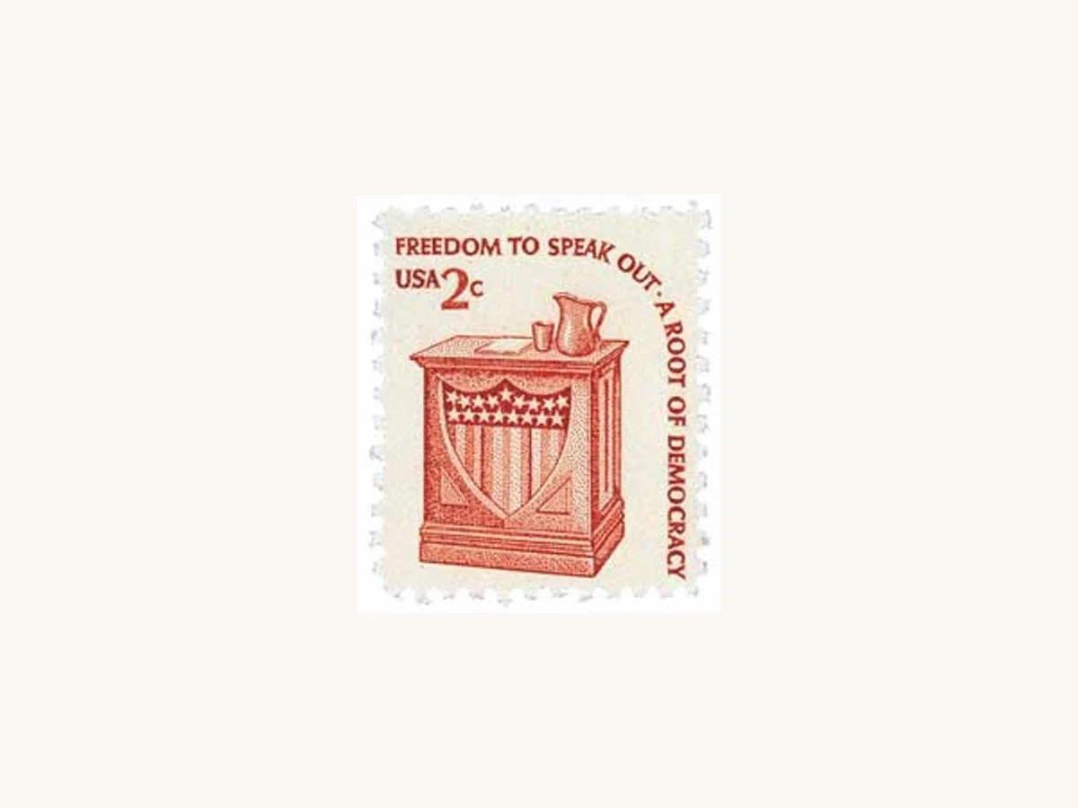 Actual low-resolution scan of the US 2-cent Americana stamp, with red speaker's stand and Freedom to Speak Out inscription